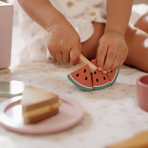 kind schneidet holzmelone 